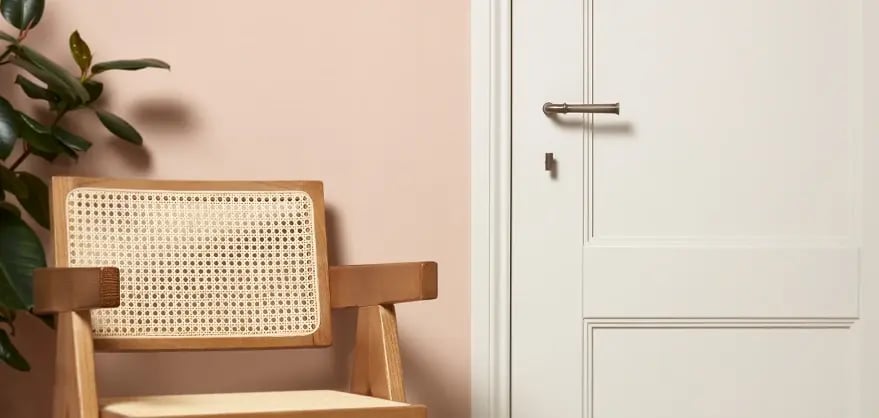 A jute chair alongside a white door