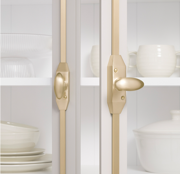 Luxury kitchen cabinet with glass doors and brass fittings, featuring cremone bolts for cabinet doors as an elegant bespoke hardware solution.