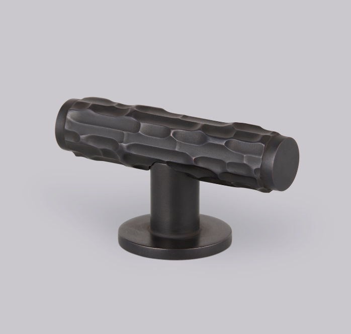 Textured dark metal cabinet knob showcasing a handcrafted finish for contemporary hardware with a patinated aesthetic.