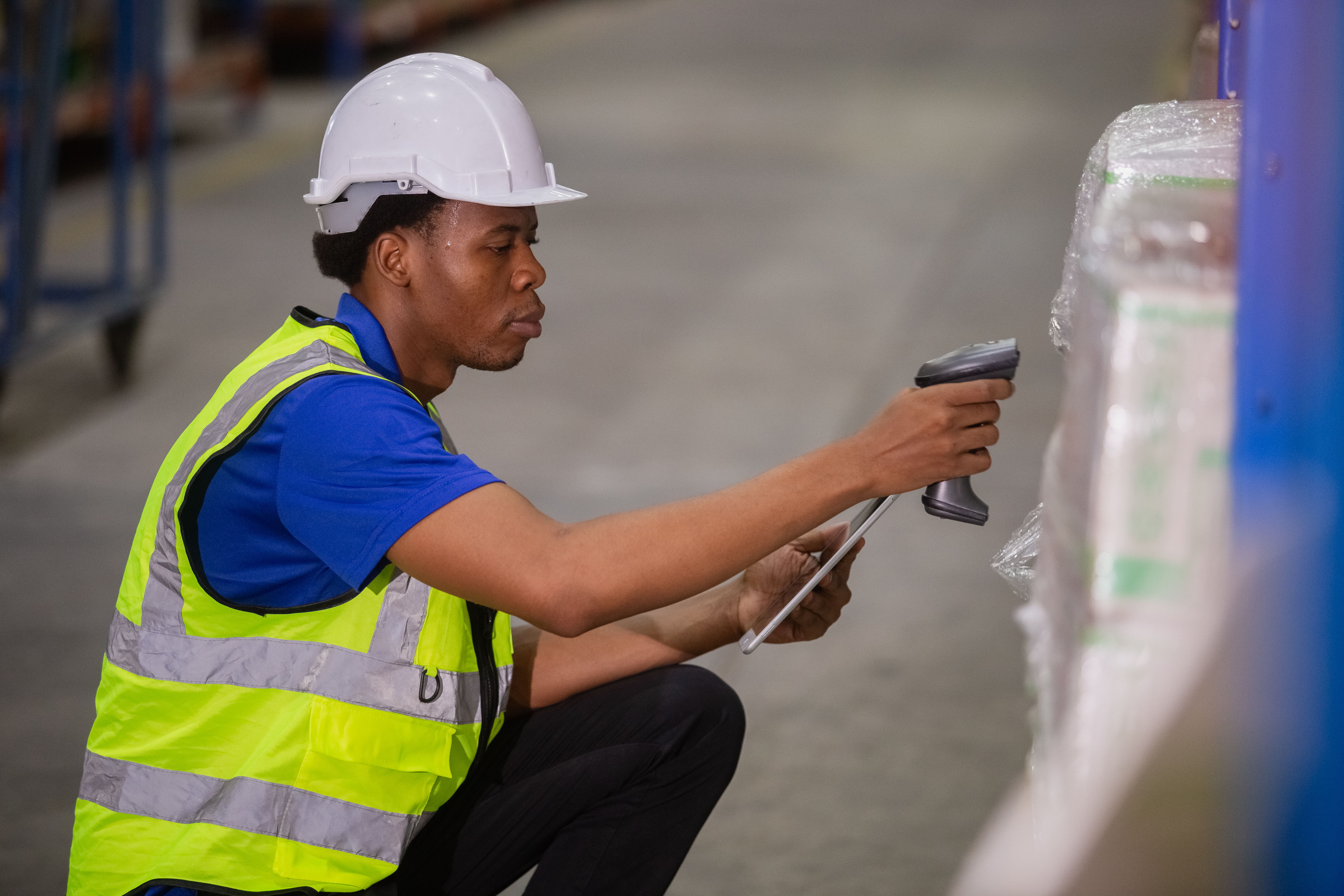 Warehouse worker scanning packaged materials to support traceability standards in the architectural hardware supply chain.